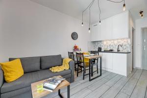 uma sala de estar e cozinha com um sofá e uma mesa em Downtown Apartments Angielska Grobla - City Center & Parking em Gdansk