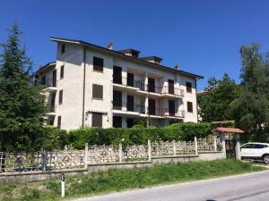 a large white building with a fence in front of it at Nice and cozy apprtment in Murazzano with panoramic view in Murazzano