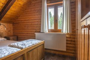 a bedroom with a bed in a wooden house at Cozy Bear Cabin in Brestova Draga
