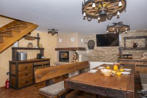 a dining room with a wooden table and a fireplace at Cozy Bear Cabin ,Brestova Draga, Mrkopalj in Brestova Draga