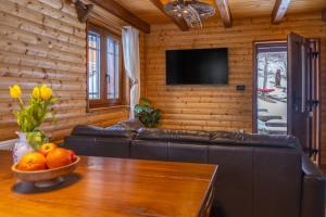 a living room with a leather couch and a table at Cozy Bear Cabin in Brestova Draga