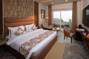 a hotel room with a large bed and a balcony at Mountoria Retreat Bhimtal- by Leisure Hotels Group in Bhīm Tāl