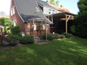 una casa de ladrillo con techo abuhardillado y patio en Ferienwohnung Annabelle, 15134, en Leer