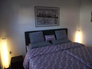 1 dormitorio con 1 cama de color púrpura con 2 luces en Ferienwohnung Annabelle, 15134, en Leer