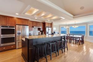 a kitchen with a large island with bar stools at Seaside Oasis Luxury Oceanfront Elevator Pool in Nags Head