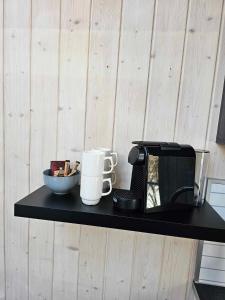 Tromsø Lodge & Camping في ترومسو: رف أسود مع آلة صنع القهوة وميكروويف