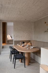 uma sala de jantar com uma mesa de madeira e cadeiras em Luxe in Het Posthuis - nieuwe Stijlvolle Verblijven in Oud-Rekem em Lanaken