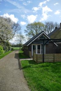 een klein huis met een hek naast een weg bij Vakantiewoning 't Stookhok Gasselte in Gasselte
