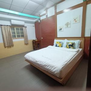 um quarto com uma cama grande com lençóis brancos e almofadas em J ancient house em Lucao