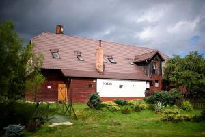 ein großes rotweißes Haus mit einem Dach in der Unterkunft Osmelakowa Dolina in Spalona