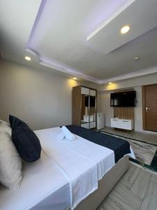 a bedroom with a large white bed and a flat screen tv at Luu Hotel in Corlu