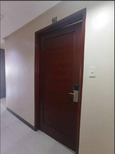 a wooden door in a wall with a handle at Spacious Studio Apartment B502 in Manila