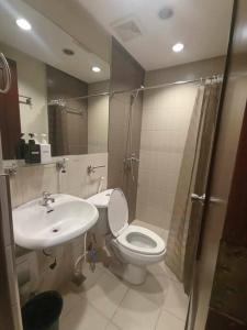 a bathroom with a toilet and a sink and a shower at Spacious Studio Apartment B502 in Manila