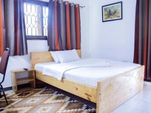 a bedroom with a wooden bed with a window at Explorers Hub in Kampala