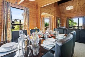 a dining room with a table and chairs and windows at Welcome to the “Mountain Gem”! in Hanmer Springs
