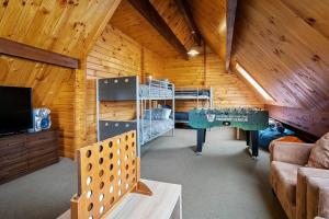 a room with bunk beds and a table in a cabin at Welcome to the “Mountain Gem”! in Hanmer Springs +11 photos