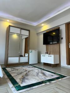 uma sala de estar com televisão e um grande tapete em Luu Hotel em Çorlu