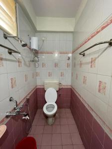 a pink bathroom with a toilet and a sink at 5 Fully Furnished 2 BHK Flats in MVP Colony, Vizag in Visakhapatnam