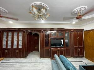 a living room with a chandelier and wooden cabinets at 5 Fully Furnished 2 BHK Flats in MVP Colony, Vizag in Visakhapatnam