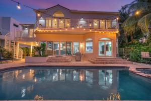 a house with a swimming pool in front of a house at Villa on Intracoastal Beach in proximity Waterfront Views Access Fogg Key VlLLAS in Fort Lauderdale