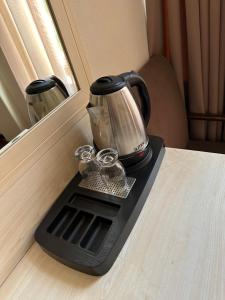 a coffee pot on a black tray on a table at Hotel Europe plaza in Tbilisi City