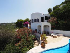 una casa con piscina frente a ella en Meervilla Mallorca - Charmantes Ferienhaus mit phantastischem Meerblick in Canyamel, en Canyamel