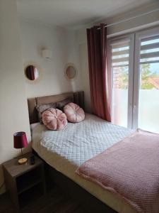 - une chambre dotée d'un lit avec des oreillers roses dans l'établissement GOLD CLIFF APARTMENT NIECHORZE Baltic Cliff, à Niechorze