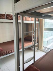 Regalia Exclusive Hostel في كوالالمبور: مجموعة من الأسرّة ذات الطابقين في غرفة مع نافذة