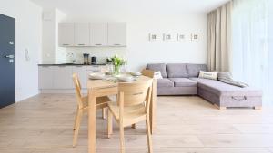 uma cozinha e sala de estar com uma mesa e um sofá em Apartamenty Sun & Snow Euronia em Międzyzdroje