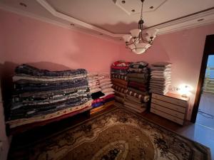 una habitación con una pila de ropa y una lámpara de araña en Eden Guest House en Corat