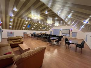 ein großes Zimmer mit Tischen und Stühlen und einer Bühne in der Unterkunft Eden Guest House in Corat