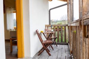 a table and chairs on the balcony of a house at Farm stay Šibav B&B in Dobrovo