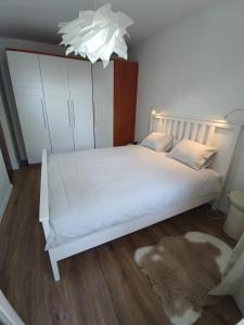 1 dormitorio con cama blanca y alfombra en Apartman Petra, en Split