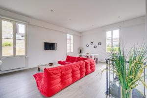 a living room with a red couch and a tv at L'Arcachonnaise by Cocoonr in Bordeaux