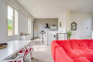 a living room with a red couch and a table at L'Arcachonnaise by Cocoonr in Bordeaux