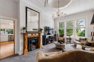 a living room with a fireplace and a mirror at Eden Park Bed And Breakfast Inn in Auckland