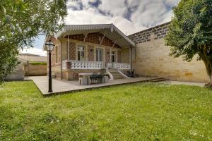 ein Haus mit einer Terrasse und einem Rasenhof in der Unterkunft L'Arcachonnaise by Cocoonr in Bordeaux