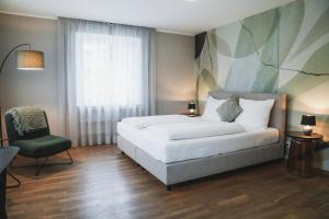 a bedroom with a bed and a chair and a window at Haus Artus in Schenna +50 photos