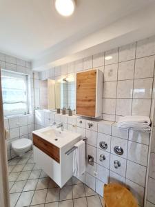 ein weißes Bad mit einem Waschbecken und einem WC in der Unterkunft Appartementhaus Bayern Residenz in Bad Füssing