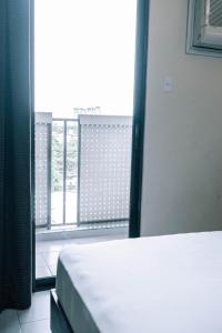 ein Schlafzimmer mit einem Bett und einem großen Fenster in der Unterkunft Tsai Hotel and Residences in Cebu City