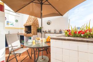 - une cuisine avec une table et un parasol dans l'établissement Ático Margarita, à Las Palmas de Gran Canaria