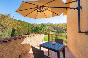 a patio with a table and an umbrella at Bonsai B&B Alghero in Santa Maria la Palma