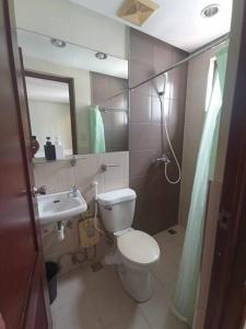 a bathroom with a toilet and a sink and a mirror at Spacious Studio Apartment B503 in Manila