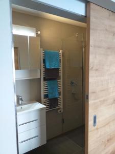 a bathroom with a sink and a shower with blue towels at Schwendter-Hof in Westendorf