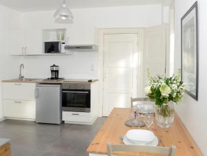 una cocina con una mesa de madera y un jarrón de flores en La corderie du Lude, en Granville