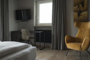 Dormitorio con cama, escritorio y TV en Haus Artus, en Scena