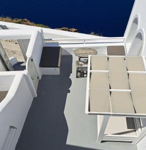 フィラにあるYposkafo Suites - Studio - Santoriniの海を望むバルコニー(椅子、テーブル付)