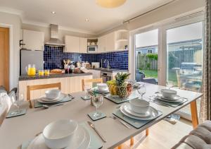 a kitchen with a table with plates and glasses on it at Lantic Surf in St Merryn
