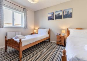 a bedroom with two twin beds and a window at Lantic Surf in St Merryn