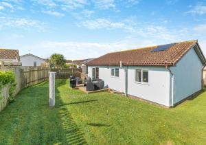 a white house with a fence and a yard at Lantic Surf in St Merryn